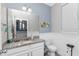 The powder room features granite counters, white vanity, framed mirror, and toilet at 16324 Brisk Breeze Aly, Winter Garden, FL 34787
