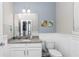 The powder room features granite counters, white vanity, and framed mirror at 16324 Brisk Breeze Aly, Winter Garden, FL 34787