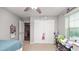 Cozy bedroom with neutral tones, features a ceiling fan, plush carpet, and ample natural light from the window at 16324 Brisk Breeze Aly, Winter Garden, FL 34787