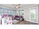 Bright bonus room with hardwood flooring, a ceiling fan, a wall of windows, and custom wall accents at 16324 Brisk Breeze Aly, Winter Garden, FL 34787