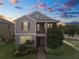 Charming two-story home with a landscaped yard, covered porch, and gray exterior at sunset at 16324 Brisk Breeze Aly, Winter Garden, FL 34787