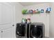 Efficient laundry room with modern washer and dryer, storage shelves, and a clean, organized layout at 16324 Brisk Breeze Aly, Winter Garden, FL 34787