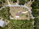 Aerial view of a charming home with a brown roof, surrounded by lush greenery and a neatly manicured lawn at 21590 Sw 84Th Loop, Dunnellon, FL 34431