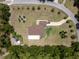 Aerial view of home with a long driveway, screened-in patio, and surrounding trees at 21590 Sw 84Th Loop, Dunnellon, FL 34431