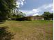 Expansive backyard view of the rear exterior of the home featuring a screened-in lanai at 21590 Sw 84Th Loop, Dunnellon, FL 34431