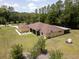 Aerial view of the backyard with its lush lawn, mature trees, and a comfortable screened lanai at 21590 Sw 84Th Loop, Dunnellon, FL 34431