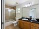 Well-lit bathroom with shower and tub, black granite countertop, and tiled flooring at 21590 Sw 84Th Loop, Dunnellon, FL 34431