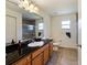 Bathroom with a large mirror, granite vanity, toilet, and shower with glass doors at 21590 Sw 84Th Loop, Dunnellon, FL 34431