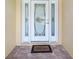 Elegant front door with decorative glass panels and a welcoming mat at 21590 Sw 84Th Loop, Dunnellon, FL 34431