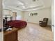Spacious main bedroom featuring tiled flooring, tray ceilings, and a cozy chair at 21590 Sw 84Th Loop, Dunnellon, FL 34431