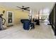 Large, covered patio with ceiling fan, dining and living areas, and an exterior entrance at 21590 Sw 84Th Loop, Dunnellon, FL 34431