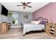 Cozy bedroom features modern ceiling fan, updated floors, large windows, and charming wood furnishings at 2869 Hickory Ridge Dr, Lakeland, FL 33813