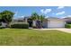 Front exterior of well maintained home with green grass and mature plants. Includes two car garage and grey trim at 2869 Hickory Ridge Dr, Lakeland, FL 33813