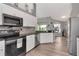 Modern kitchen features white cabinets, stainless steel appliances, and wood-look flooring at 2869 Hickory Ridge Dr, Lakeland, FL 33813