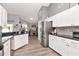 Beautiful kitchen featuring white cabinets, granite countertops, stainless steel appliances, and views of the living area at 2869 Hickory Ridge Dr, Lakeland, FL 33813