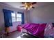 Blue bedroom with a window and ceiling fan, with pink bedding on a bed frame at 1818 Fredricksburg Ave, Lakeland, FL 33803