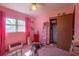 Pink bedroom featuring two windows, ceiling fan, closet, and pink curtains at 1818 Fredricksburg Ave, Lakeland, FL 33803