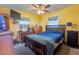 Yellow bedroom with a dark wood bed set and two windows with an AC unit at 1818 Fredricksburg Ave, Lakeland, FL 33803