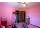 Pink bedroom featuring a ceiling fan, closet, boxes, and various home goods at 1818 Fredricksburg Ave, Lakeland, FL 33803