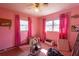 Pink bedroom featuring two windows, ceiling fan, and Harley Davidson wall decor at 1818 Fredricksburg Ave, Lakeland, FL 33803