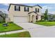 Beige two-story home showcasing a well-manicured lawn and a spacious driveway at 2175 Old Mining Rd, Lakeland, FL 33801