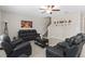 Cozy living room with tile flooring, ceiling fan, and comfortable black leather furniture at 2175 Old Mining Rd, Lakeland, FL 33801