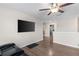 Modern living room area featuring wood-look floors, a ceiling fan and a mounted flatscreen television at 2175 Old Mining Rd, Lakeland, FL 33801