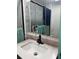 Bathroom featuring a sink, faucet, framed mirror with storage, and a walk-in shower at 225 N Palmetto Ave, Fort Meade, FL 33841