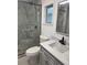 Bathroom featuring a toilet and vanity with a walk-in shower, framed mirror and a large window at 225 N Palmetto Ave, Fort Meade, FL 33841