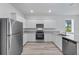 Modern kitchen features stainless steel appliances, granite countertops, and white cabinets at 247 Big Sioux Dr, Poinciana, FL 34759