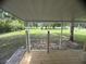 A wooden back porch looks out onto the green, expansive lawn beyond at 2777 Cr 673, Bushnell, FL 33513