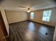 A cozy bedroom with wood-look flooring, a ceiling fan, and natural light streaming through two windows at 2777 Cr 673, Bushnell, FL 33513