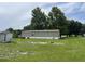 Distant side view of home and exterior with siding and perimeter of trees at 2777 Cr 673, Bushnell, FL 33513