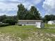 Home exterior surrounded by lush green grass and mature trees under a blue sky at 2777 Cr 673, Bushnell, FL 33513