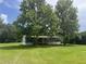 Charming home nestled among mature trees, featuring a welcoming porch and a lush green lawn at 2777 Cr 673, Bushnell, FL 33513