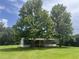 Quaint single-story home with neutral siding and mature trees in a sprawling lawn at 2777 Cr 673, Bushnell, FL 33513