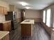 Kitchen with stainless steel appliances, a central island with a sink, and sleek wood-look flooring at 2777 Cr 673, Bushnell, FL 33513