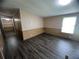 A spacious living room featuring modern wood-look flooring, neutral walls, and a bright window at 2777 Cr 673, Bushnell, FL 33513