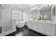 Bathroom featuring a modern tub, glass shower, dual vanity, and dark tile flooring at 5233 Los Palma Vista Dr, Orlando, FL 32837