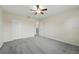 Neutral bedroom features a ceiling fan, a closet with double doors, and plush gray carpeting at 5233 Los Palma Vista Dr, Orlando, FL 32837
