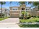 Charming two-story tan home with a well-maintained lawn, inviting curb appeal, and a two-car garage at 5233 Los Palma Vista Dr, Orlando, FL 32837