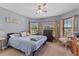 Comfortable bedroom featuring a ceiling fan, wooden dresser, and bright windows for a peaceful and airy atmosphere at 1955 Manatee Ct, Kissimmee, FL 34759