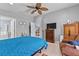 Bright bedroom with a blue comforter, wooden furniture, and a ceiling fan, creating a relaxing and inviting space at 1955 Manatee Ct, Kissimmee, FL 34759