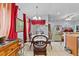 Bright dining room with glass-top table, modern chandelier, and red accents offering a cozy and inviting atmosphere at 1955 Manatee Ct, Kissimmee, FL 34759