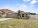 Charming single-story home with a two-car garage, a well-manicured lawn, and tidy landscaping at 1955 Manatee Ct, Kissimmee, FL 34759