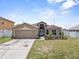 Charming single-story home with a two-car garage, tidy landscaping, and a well-manicured lawn at 1955 Manatee Ct, Kissimmee, FL 34759