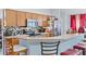 Open kitchen with wood cabinetry, a breakfast bar, stainless steel appliances, and tile backsplash at 1955 Manatee Ct, Kissimmee, FL 34759