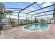Refreshing screened-in pool area with brick patio and lush green landscaping at 1955 Manatee Ct, Kissimmee, FL 34759