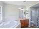 Bathroom featuring large tub, dual sinks, and enclosed toilet and shower at 316 Red Kite Dr, Groveland, FL 34736