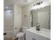 Bright bathroom featuring a vanity with modern fixtures, a large mirror, and a tiled shower/tub combo at 316 Red Kite Dr, Groveland, FL 34736